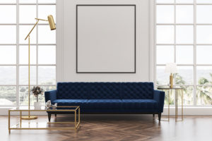 White living room interior with a wooden floor loft windows a blue sofa a coffee table and a framed vertical poster on a white wall. 3d rendering mock up