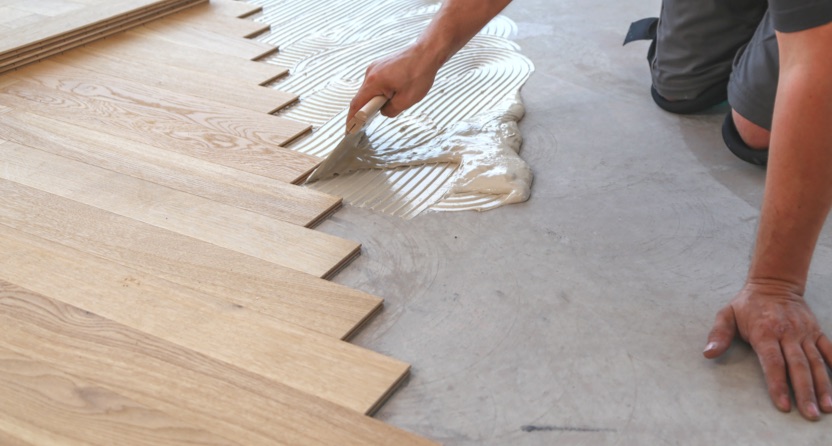 Man laying grout for wooden flooring