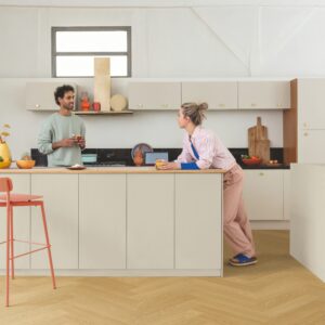 Man and women in a kitchen with Quick-Step Ciro Pure Oak Honey flooring